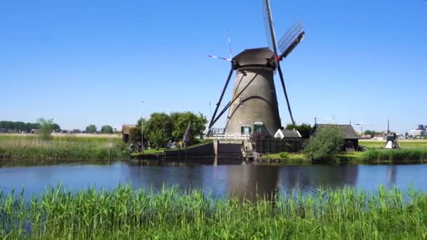 Dutch windmill over river waters — Stock Video