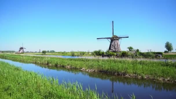 Dutch windmill over river waters — Stock Video