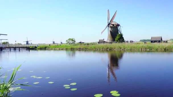 Dutch windmill over river waters — Stock Video