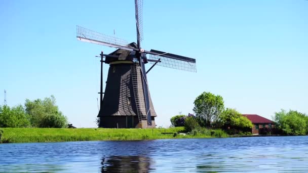 Dutch windmill over river waters — Stock Video