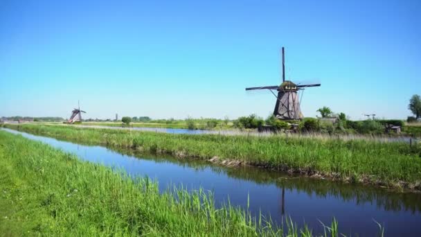 Dutch windmill over river waters — Stock Video