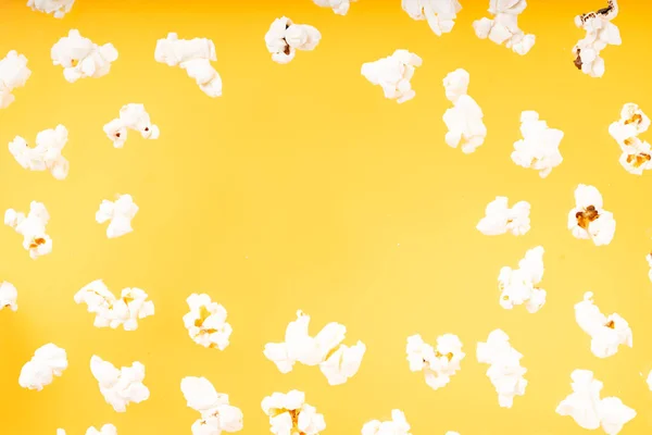 Рассеянный попкорн на жёлтом фоне — стоковое фото