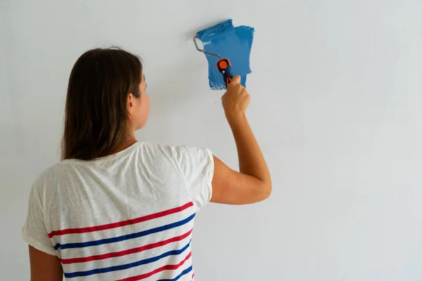 Vrouw schildert muur — Stockfoto