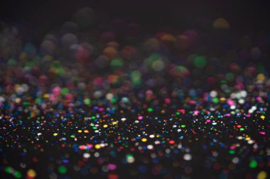 Güzel bir Noel ışığı arka planı. Soyut parıltı bokeh ve saçılmış altın parıltıları, siyah üzerine