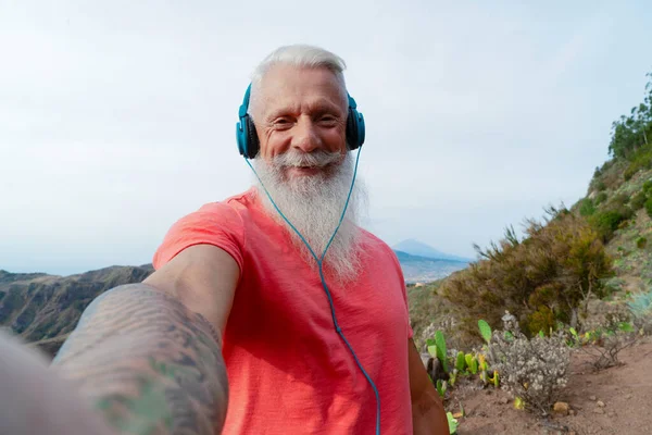 Бородатый старший с помощью мобильного телефона на открытом воздухе — стоковое фото