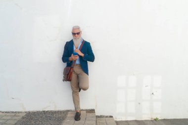 Telefonu olan yaşlı bir adam.