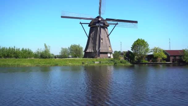 Dutch windmill over river waters — Stock Video