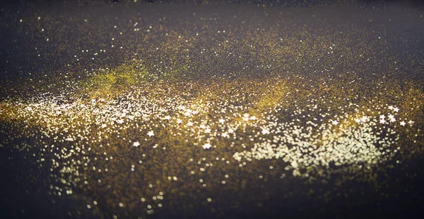Hermoso fondo de luz de Navidad. Bokeh brillo abstracto y destellos dispersos en color oro, en negro — Foto de Stock