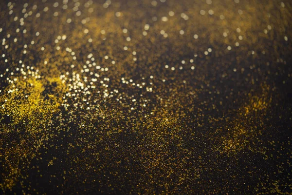 Bela luz de Natal fundo. Abstrato glitter bokeh e brilhos espalhados em ouro, em preto — Fotografia de Stock