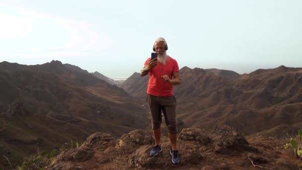 Barbudo senior usando teléfono móvil al aire libre — Vídeo de stock