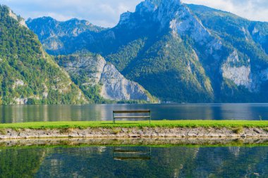 Büyüleyici dağlar ve yukarıdaki hafif sisli bulutlar arasında pitoresk bir Hallstatt gölü, Avusturya