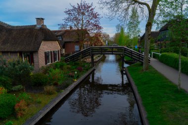 Hollanda 'nın kırsal kesimlerinde eski küçük bir kasaba olan Giethoorn' da kanallar ve köprüler, Hollanda manzarası