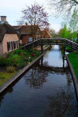 Hollanda 'nın kırsal kesimlerinde eski küçük bir kasaba olan Giethoorn' da kanallar ve köprüler, Hollanda manzarası