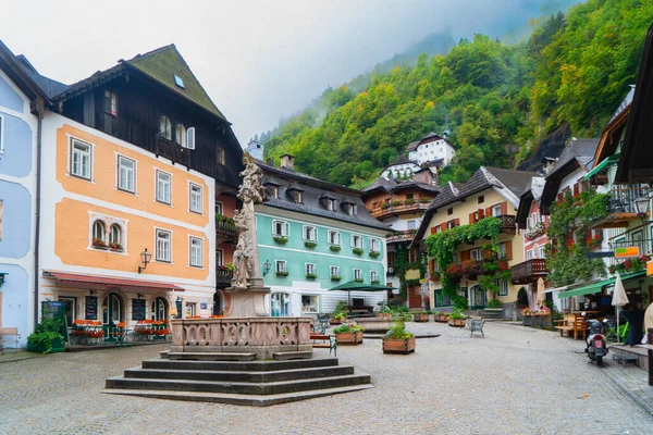 Göz kamaştırıcı dağlarla yukardaki bulutlar arasında güzelce yuva yapmış güzel bir Hallstatt göl kenarı köyü, Avusturya