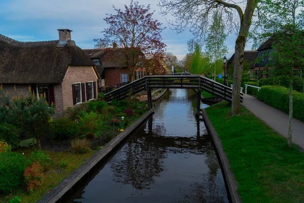 Hollanda 'nın kırsal kesimlerinde eski küçük bir kasaba olan Giethoorn' da kanallar ve köprüler, Hollanda manzarası