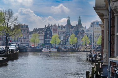 Amstel kanal suyu üzerinde eski tarihi evler ve ağaçların cepheleri, Amsterdam, Hollanda