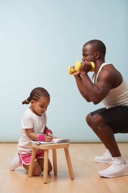 Sevimli küçük kızı fitness yakışıklı siyah genç babası eğitim. Onun kağıt defter notları yapıyor. Çocuk rol yapma. Onaylanmak, ağız kavgası yaparken ona bakar. Bitkin. Son gönderme.