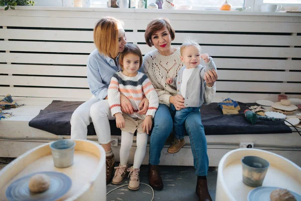 Щаслива сім'я з двома дітьми, сидячи разом і дивлячись на камеру — стокове фото
