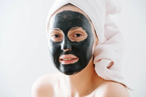 Молодая женщина с бамбуком снимает маску для лица из угля — стоковое фото
