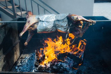 Büyük bir el yapımı kavurma açık ateş üzerinde pişirme şiş üzerinde pişmiş domuz karkas