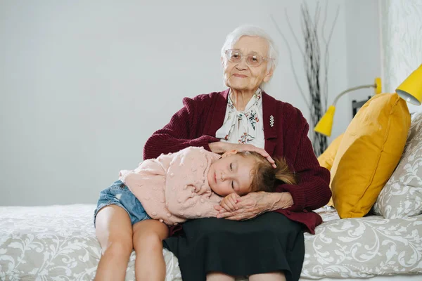 Happy moments. Little girl with her great grandma spending quality time together — Stock Photo, Image