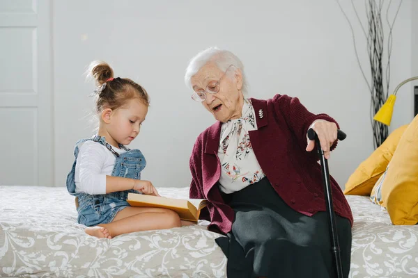 Happy moments. Little girl with her great grandma spending quality time together