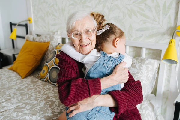 Happy moments. Little girl with her great grandma spending quality time together
