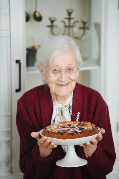 Portrait of a senior woman presenting tasty holiday pie — Stock Photo, Image
