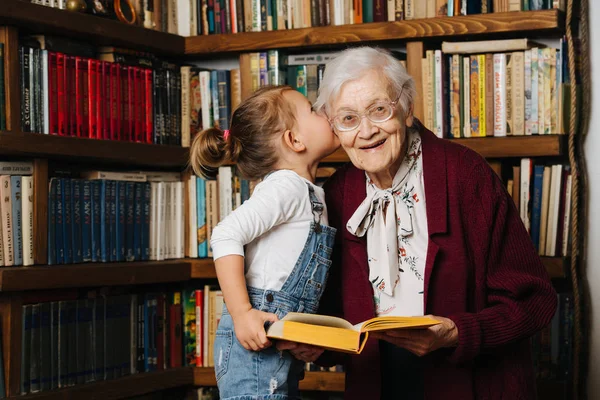 Des moments heureux. Petite fille avec son arrière grand-mère passer du temps de qualité ensemble Photo De Stock