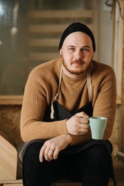 Marangoz bir atölyede sipariş mobilya yapımına bir mola veriyor.