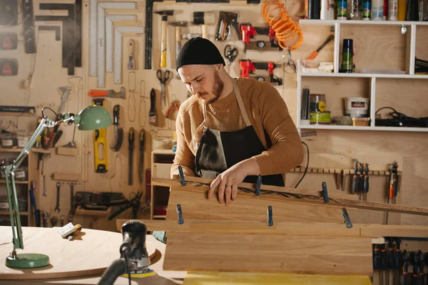 Charpentier fabrique des meubles sur commande dans un atelier . — Photo