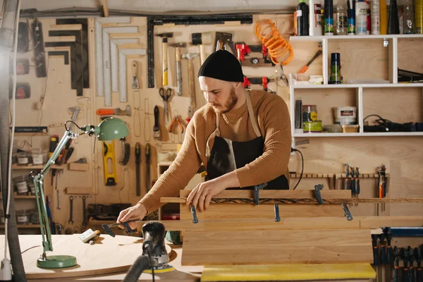 Charpentier fabrique des meubles sur commande dans un atelier . — Photo