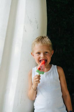 Çocuk yeme, yaz sıcak güneşli bir günde onun karpuz dondurma zevk