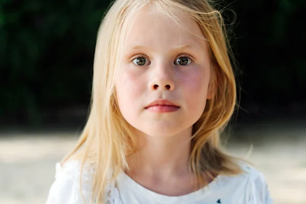 Porträt eines kleinen blonden Mädchens mit verschwommenem Hintergrund — Stockfoto
