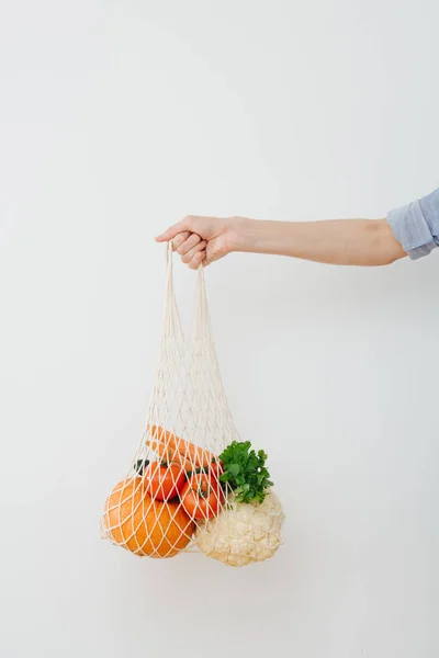 Bolsa de corda mão segurando com legumes — Fotografia de Stock