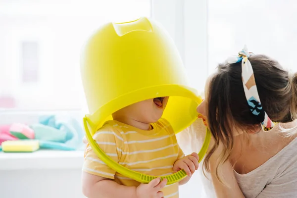 Funny little blond toddler boy is wearing big plastic bucket — Stock Photo, Image