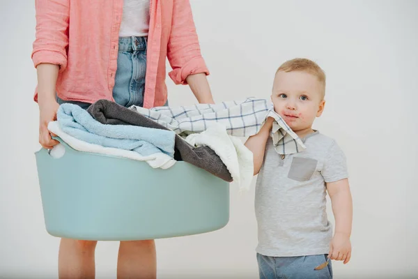 Mother with laundry basin full of cloth and her child with mouth dirty in jam — Stock Photo, Image