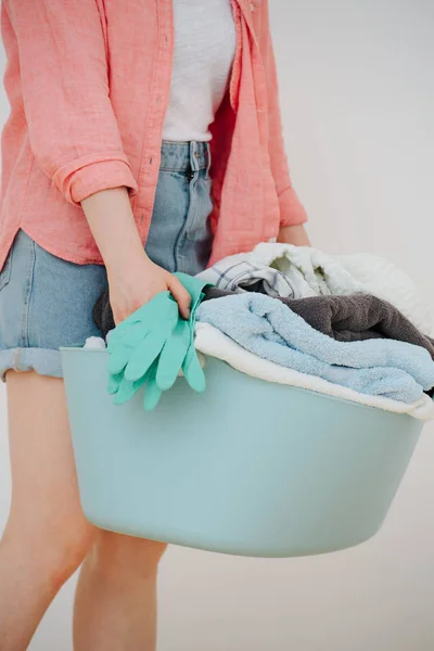 Kobieta z umywalką pełną ręczników — Zdjęcie stockowe