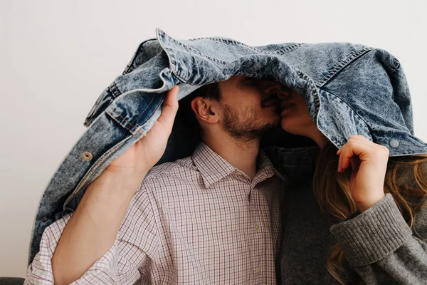 Um belo casal está a passar tempo juntos. Escondendo-se principalmente sob uma jaqueta — Fotografia de Stock