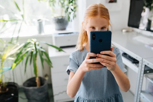 Rødhåret tenåringsjente tar bilde med smarttelefonen – stockfoto