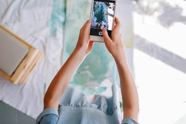 Tiener Redhead meisje is het nemen van foto van haar schilderij met haar Smartphone — Stockfoto