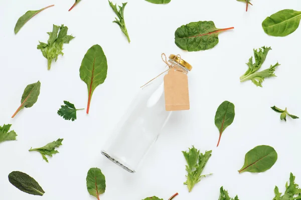 Bitkisel soyut arka plan üzerinde Etiketli süt şişesi, salata yapraklarından yapılmış — Stok fotoğraf