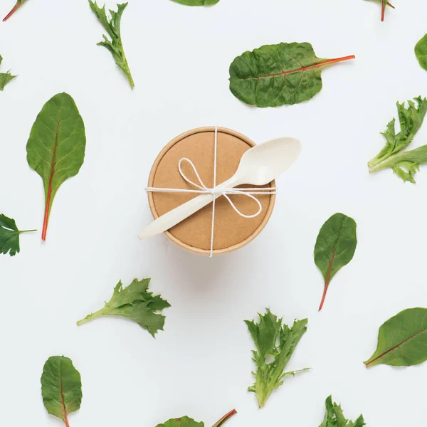 Warm voedsel container over plantaardige abstracte achtergrond, gemaakt van salade bladeren — Stockfoto