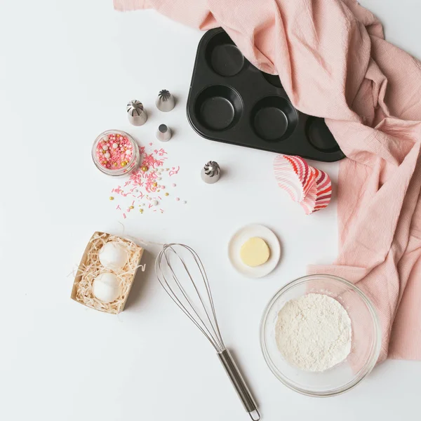 Baking tools, cases and ingredients over white background