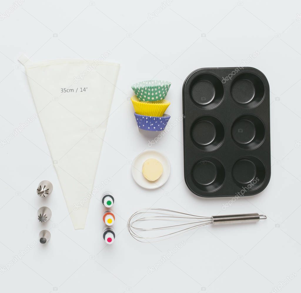 Baking tools, cases and ingredients over white background