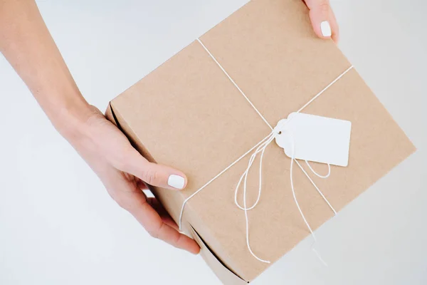 Woman hands presenting postal cardboard box