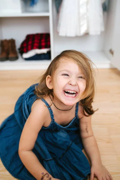 Kis Jolly lány próbál új ruhát előtt nyitott szekrény tele ruhák — Stock Fotó