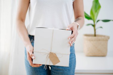 Posta karton kutu tutan dikey rahat giysiler içinde bir kadının portresi