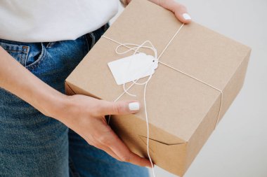 Posta karton kutu tutan rahat giysiler içinde bir kadının portresi
