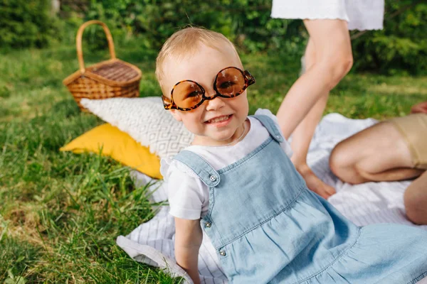 Aranyos csecsemő lány játszik, mutatja ki során piknik fű a kertekben — Stock Fotó